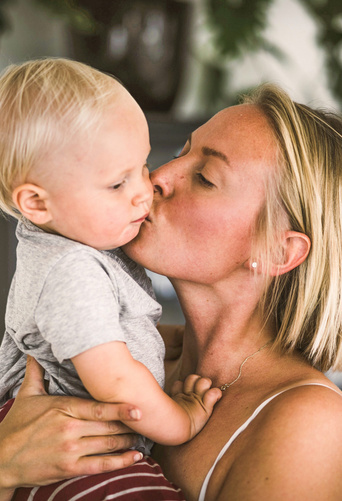 mom kissing her baby 