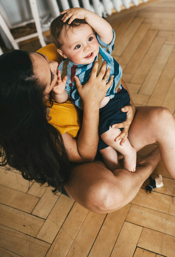 MAdre mirando a su bebe sujetandolo